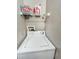 A laundry area showcases a white washing machine and shelf for storing supplies at 4850 51St W St # 4205, Bradenton, FL 34210