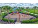 Community playground with swings, slides, and climbing structure surrounded by lush landscaping at 4984 Seafoam Trl, Bradenton, FL 34211
