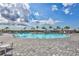 Community pool showcasing crystal-clear water, inviting lounge areas and palm tree landscaping at 4984 Seafoam Trl, Bradenton, FL 34211