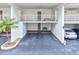 Covered parking area with two storage closets, assigned parking spots and a green bench at 5055 Gulf Of Mexico Dr # 115, Longboat Key, FL 34228