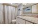 Bathroom featuring a granite countertop, framed mirror, grey tiled floors, and tiled shower with curtain at 515 Spring Lakes Blvd # 515, Bradenton, FL 34210