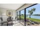 Sun room features a glass-top dining table and wall-to-wall windows with scenic views of the lake at 515 Spring Lakes Blvd # 515, Bradenton, FL 34210