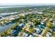Sweeping aerial view of a neighborhood with waterfront access, mature trees, and a mix of residential and commercial properties at 5247 Carmilfra Dr, Sarasota, FL 34231