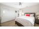 Bedroom with wood floors, a ceiling fan, closet, and neutral-toned bedding with red accent pillow at 5247 Carmilfra Dr, Sarasota, FL 34231