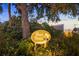 Well-lit River Forest community sign amidst lush landscaping at dusk at 5247 Carmilfra Dr, Sarasota, FL 34231