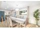 Dining area featuring a chandelier, large window, wood floors, and neutral decor at 5247 Carmilfra Dr, Sarasota, FL 34231