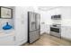 Well-lit kitchen featuring stainless steel appliances, white cabinets, and hardwood floors at 5247 Carmilfra Dr, Sarasota, FL 34231