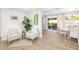 Cozy living area featuring hardwood floors, stylish seating, and a bright dining space with sliding glass doors at 5247 Carmilfra Dr, Sarasota, FL 34231