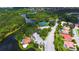 An aerial view showcasing the community's landscape, featuring mature trees, a tranquil lake, and multiple tennis courts at 5270 Far Oak Cir, Sarasota, FL 34238