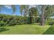 Lush backyard showcases a manicured lawn with privacy hedges and mature trees, creating a serene outdoor oasis at 5270 Far Oak Cir, Sarasota, FL 34238