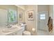 Half bath with a wide mirror over the vanity, toilet, and a separate door to the shower at 5270 Far Oak Cir, Sarasota, FL 34238