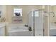 Bright bathroom with a large soaking tub, glass block windows, and a separate glass shower at 5270 Far Oak Cir, Sarasota, FL 34238