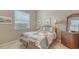 Neutral bedroom with light colored carpet, bed with quilt and woven wood dresser at 5270 Far Oak Cir, Sarasota, FL 34238