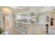 Eat-in kitchen with white cabinetry, breakfast bar, and view into the doorway to the en-suite bathroom at 5270 Far Oak Cir, Sarasota, FL 34238
