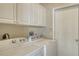 Functional laundry room is equipped with a washer, dryer, and overhead cabinets, providing ample storage at 5270 Far Oak Cir, Sarasota, FL 34238