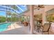 Covered patio with ceiling fans offers ample seating with a table and chairs, perfect for outdoor dining and entertaining at 5270 Far Oak Cir, Sarasota, FL 34238