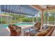 Covered patio with wicker furniture overlooking a pool and lush landscaping at 5270 Far Oak Cir, Sarasota, FL 34238
