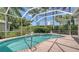 Sparkling pool and integrated hot tub under a screened enclosure, surrounded by well-maintained landscaping at 5270 Far Oak Cir, Sarasota, FL 34238