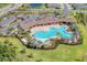 High-angle view of a community pool and clubhouse with lounge chairs, tropical plants, and manicured lawns at 5336 Grove Mill Loop, Lakewood Ranch, FL 34211