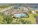 Wide aerial perspective of a vibrant community pool and clubhouse with nearby ponds, residential streets, and homes at 5336 Grove Mill Loop, Lakewood Ranch, FL 34211