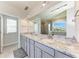 Bathroom boasts double sinks with a sleek gray vanity and granite countertops at 5336 Grove Mill Loop, Lakewood Ranch, FL 34211