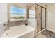 Beautiful bathroom features a tub, tiled shower, and a bright window view at 5336 Grove Mill Loop, Lakewood Ranch, FL 34211