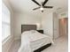 Well-lit bedroom featuring plush carpeting, a ceiling fan, and a window at 5336 Grove Mill Loop, Lakewood Ranch, FL 34211
