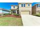 Two-story home with tan exterior, stone accents, well-maintained landscaping, and a two-car garage at 5336 Grove Mill Loop, Lakewood Ranch, FL 34211