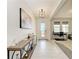 Bright foyer with tiled floors, stylish console table, modern light fixture and adjacent office at 5336 Grove Mill Loop, Lakewood Ranch, FL 34211