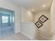 Upstairs hallway with carpet, decorative artwork and a door to the bedroom at 5336 Grove Mill Loop, Lakewood Ranch, FL 34211