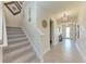 Hallway features tiled floors, staircase, and a stylish pendant light fixture at 5336 Grove Mill Loop, Lakewood Ranch, FL 34211