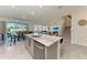 Open kitchen with island seating flows into living and dining area, perfect for entertaining at 5336 Grove Mill Loop, Lakewood Ranch, FL 34211