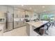 Contemporary kitchen with stainless appliances, gray cabinets, and a large center island with bar stool seating at 5336 Grove Mill Loop, Lakewood Ranch, FL 34211