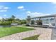 Beautiful backyard featuring a manicured lawn, waterside landscaping, and an enclosed lanai at 5563 America Dr, Sarasota, FL 34231