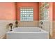 Beautiful bathtub with glass block windows and decor, perfect for relaxing at 5563 America Dr, Sarasota, FL 34231