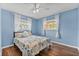 Cozy bedroom featuring hardwood floors, natural light, and a ceiling fan at 5563 America Dr, Sarasota, FL 34231