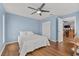 Bright bedroom features blue walls, hardwood floors, and a ceiling fan at 5563 America Dr, Sarasota, FL 34231