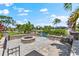 Charming waterfront outdoor space features a fire pit with lush greenery and scenic views at 5563 America Dr, Sarasota, FL 34231