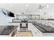 Modern kitchen with granite countertops, stainless steel appliances, tile backsplash, and island counter at 5563 America Dr, Sarasota, FL 34231