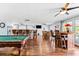 Open-concept living room with a pool table, wet bar, and hardwood floors, perfect for entertaining at 5563 America Dr, Sarasota, FL 34231
