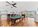 Large living area boasts a pool table, wet bar, hardwood floors, and access to an outdoor pool at 5563 America Dr, Sarasota, FL 34231