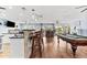 Expansive living room features a pool table, wet bar, hardwood floors, and plenty of natural light at 5563 America Dr, Sarasota, FL 34231