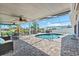 Relaxing screened-in lanai with a kidney-shaped pool, comfortable seating, and lush landscaping at 5563 America Dr, Sarasota, FL 34231