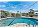Outdoor pool with screened enclosure, patio, and views of the landscaped backyard at 5563 America Dr, Sarasota, FL 34231