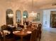 Elegant dining room featuring a chandelier, arched mirrors, and a view into other rooms at 5714 Garden Lakes Dr, Bradenton, FL 34203