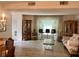 Open-concept living room with tile flooring, large window with curtains, and comfortable seating arrangement at 5714 Garden Lakes Dr, Bradenton, FL 34203