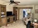 Comfortable living room with tile flooring, entertainment center, ceiling fan, and cozy seating area at 5714 Garden Lakes Dr, Bradenton, FL 34203