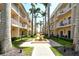Well manicured grounds with green grass, palm trees, sidewalks, fountain, and condominium buildings at 5963 Midnight Pass Rd # 355, Sarasota, FL 34242