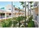 Exterior view of the building showcasing multiple balconies surrounded by tropical palm trees and landscaping at 5963 Midnight Pass Rd # 355, Sarasota, FL 34242
