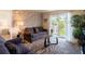 Bright living room with a stone accent wall, modern furnishings, and sliding glass doors to the balcony at 5963 Midnight Pass Rd # 355, Sarasota, FL 34242